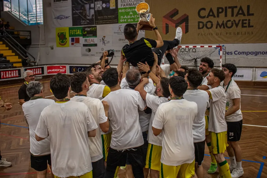 Os atletas da equipa sénior de futsal celebram o título com o mister Nandinho.